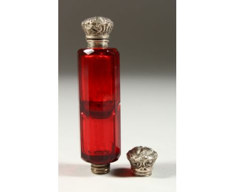 A VICTORIAN RUBY FACET CUT DOUBLE ENDED SCENT BOTTLE with repousse silver caps. 10cms long.