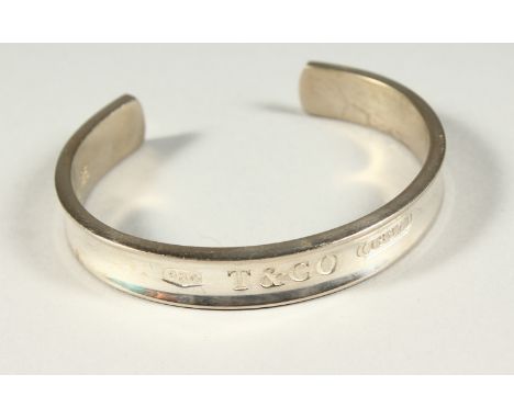 A TIFFANY &amp; CO CIRCULAR BANGLE in original box.