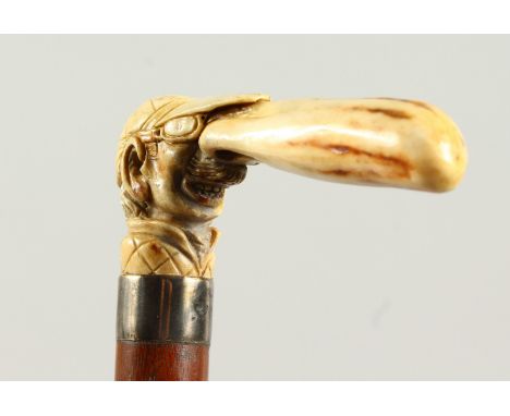 A WALKING STICK with carved ivory handle, a jockey with a long nose. 2ft 10ins long.