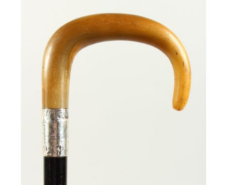 A LATE 19TH CENTURY WALKING STICK, with rhino horn handle, engraved silver collar, and ebonised shaft. 88cms long.