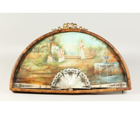 A GOOD FRAMED AND GLAZED 18TH-19TH CENTURY FRENCH MOTHER-OF-PEARL FAN, painted with a classical garden scene with young ladie