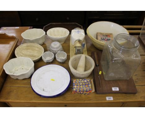A quantity of various kitchenalia to include four jelly moulds; enamel plates; a coffee grinder; a large mixing bowl etc. 