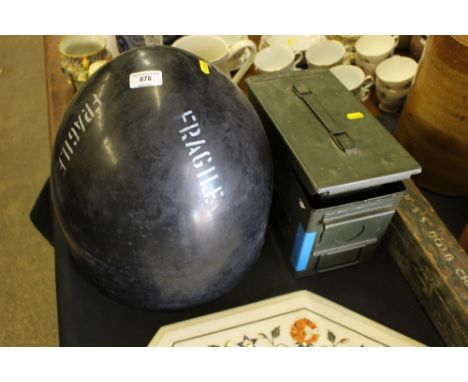 An ammunition box with contents of blank ammo belts; a nose cone from a Sting Ray torpedo; and a military slide rule in woode
