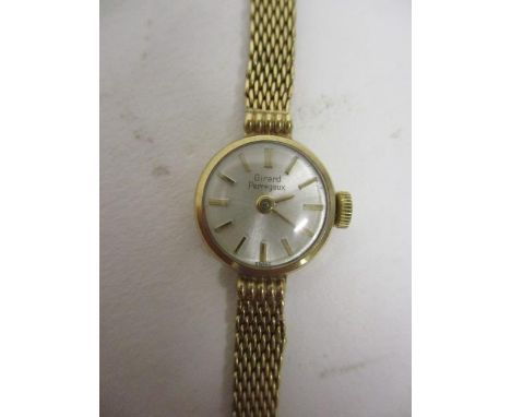A Girard Perregaux ladies manual wind, 9ct gold cased wristwatch having a silvered dial, baton numerals and on a 9ct gold bra