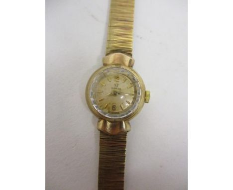 An Omega ladies manual wind, 9ct gold cased wristwatch, the watch glass with bevelled edge on a 9ct gold bracelet, 17mm 