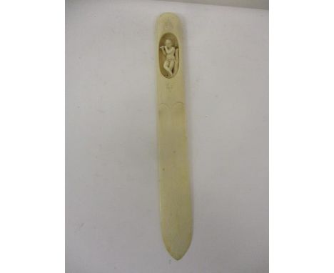 A late 19th century European ivory page turned, the handle carved with a recessed boy playing a flute, 10 3/4" l 