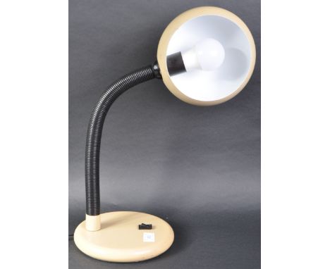 A retro 20th Century German desk / table lamp light having a beige finished eyeball style shade supported by a black plastic 