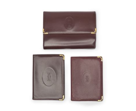 in burgundy leather. A wallet with button closure, interior with card holder, cash compartment, coin holder and check holder.