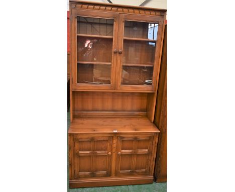 An Ercol bookcase, glazed doors enclosing adjustable shelves above a pair of cupboard doors, 196.5cm high