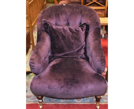 A Victorian style button back reception armchair, brass casters