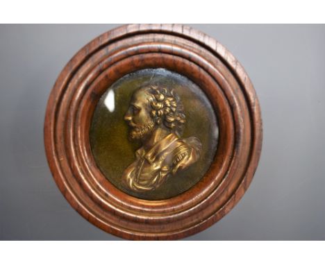 A 19th century brass portrait plaque, of William Shakespeare, bust length in profile, 7cm diam, turned oak frame