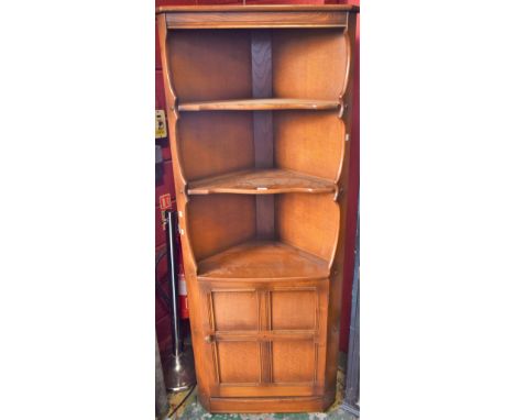 An Ercol corner display cabinet, shaped cornice above two shelves, single cupboard door to base, 183cm high