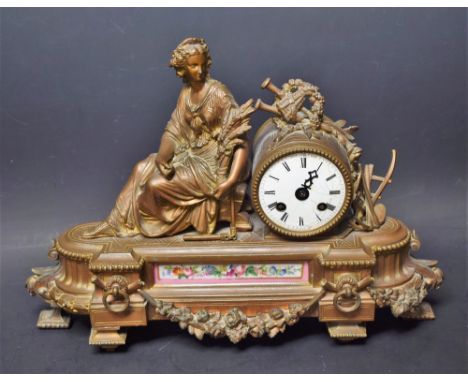 A 19th century style French figural mantel clock, cast as a seated young maiden holding a wheatsheaf by a musical trophy, whi