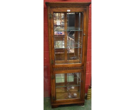 An oak Old Charm display cabinet, glazed and leaded door enclosing an adjustable glass shelf above a further door, 168cm high