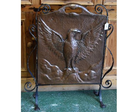 An Arts and Crafts beaten copper and wrought iron fire screen, repousse embossed with an eagle displayed, pierced carrying ha