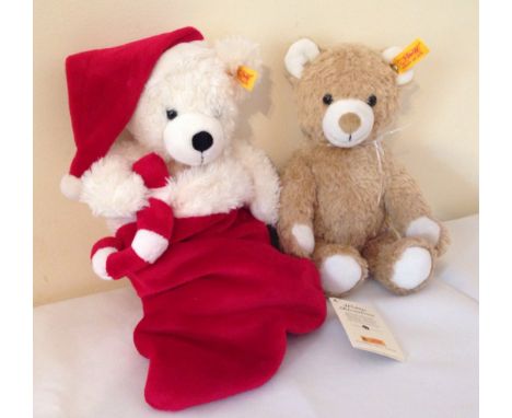 2 Steiff teddy bears with buttons and gold labels. Comprises of #111525 white bear in a Christmas stocking with information l