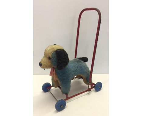 A vintage push-along soft toy dog. Dog is by Chiltern, wheels by Chad Valley. 