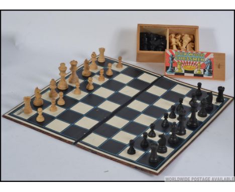 A vintage mid century boxed boxwood chess set together with another chess set and a folding board