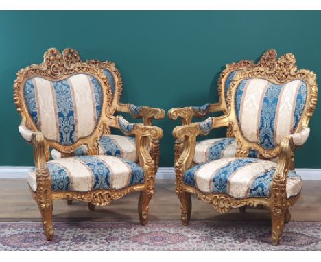 A Rococo style gilded Settee with acanthus leaf and scroll carved decoration and blue and cream striped floral upholstery 6ft