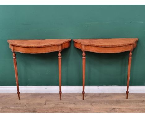 A pair of Sheraton style satinwood and inlaid Console Tables with serpentine fronts raised on octagonal and turned tapering s