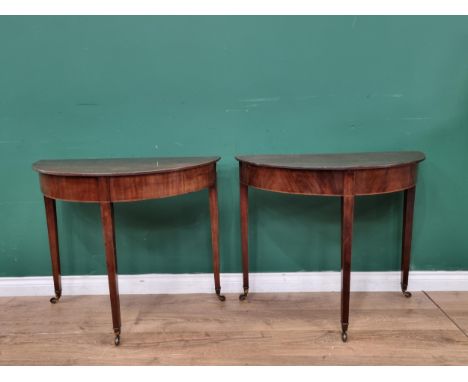 A pair of 19th Century mahogany D-shaped Side/Console Tables, raised on square tapered supports and castors, 2ft 4in H x 2ft 