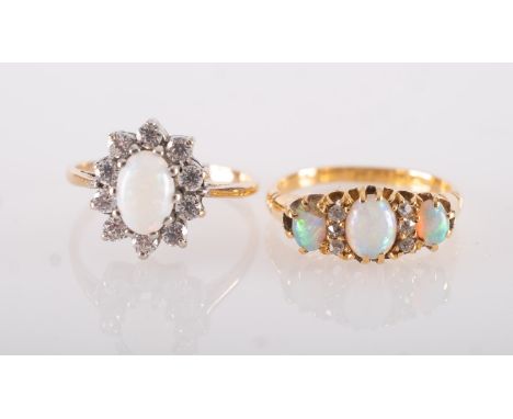 Two opal set rings, including an early 20th century 18ct yellow gold ring set with three oval opal cabochons, interspaced by 