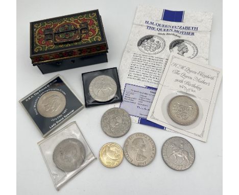 A small collection of British coins and commemorative crowns together with a small vintage cash tin. Coins include a Queen Mo