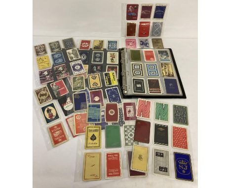 A folder containing a collection of vintage single playing cards with backs featuring advertising. 