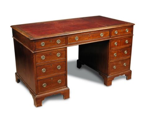 A 19th century mahogany pedestal desk, red leather lined writing surface, fitted nine drawers with brass ring handles, on bra