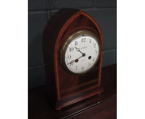 A late 19th century mahogany lancet shaped cased mantel clock, striking on a bell, the circular white enamel dial signed Mumf