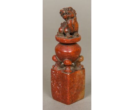 A Chinese carved stone seal, worked with a temple lion, seated upon a censer, the matrix with archaistic seal.  13 cm high. 