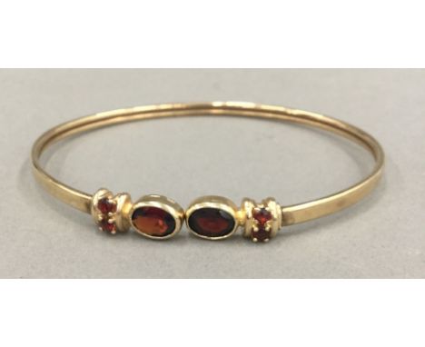 A 9 ct gold and almandine garnet bangle (8.5 grammes total weight)