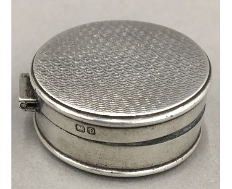 A small silver patch box