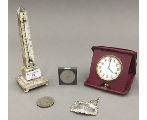 A mother-of-pearl thermometer, a travelling clock, a silver decanter label, etc.