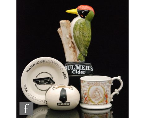 A Carltonware Bulmers Woodpecker advertising figure, height 18.5cm, a Sandeman ashtray, a Wade domino ashtray and an 1899 com
