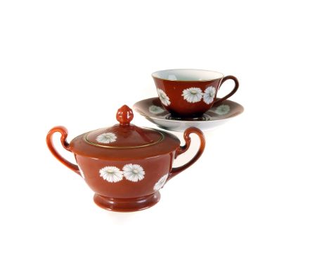 A Japanese Noritake porcelain tea service, having red ground and decorated with chrysanthemums, including teapot, sugar basin