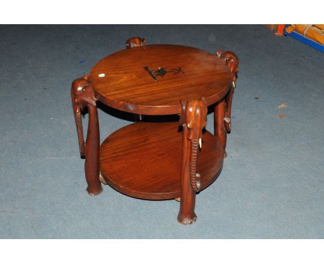 An Art Deco period African hardwood occasional table, having four elephant head, trunk and foot supports, with circular inlai