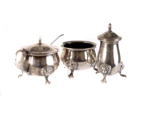 A silver three piece cruet set by Walker & Hall,  Birmingham 1950, with lion and paw feet, mustard and salt with blue glass l