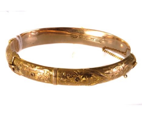 A pretty 9ct gold bangle, having one half engraved and modelled as a buckle, with safety chain, hallmarked an stamped wax fil