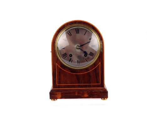 An Edwardian mahogany and strung mantle clock, the domed case with silvered dial marked with Roman numerals, movement with tw