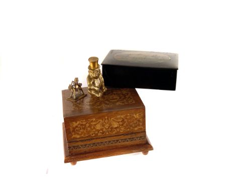 A novelty gilt lighter, modelled as a monkey in a top hat, together with three small metal items, possibly opium weights, an 