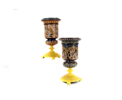 Two Royal Doulton stoneware urns, possibly once oil lamp bases, both with scrafitto floral panels and decorated borders, both