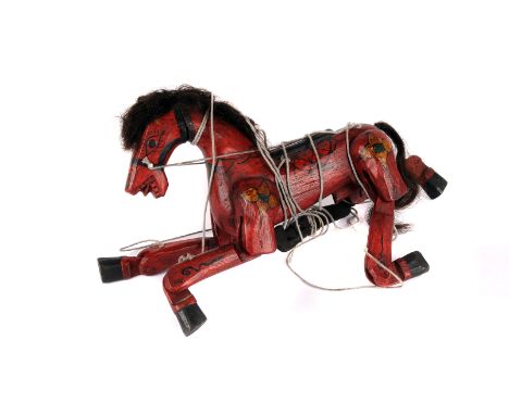 An Indian wooden painted horse puppet, in red with black painted detail and decoration in colours, with articulated joints an
