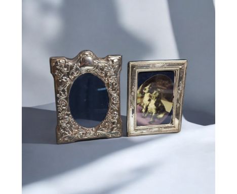 Two silver mounted photo frames, comprising: one with embossed with putti and foliate scrolls, D R &amp; S, Sheffield 1990; a