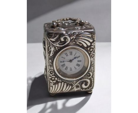 Late Victorian silver cased travelling clock, Charles Henry Dumenil, London 1892, the case embossed with scrolls and flowers,