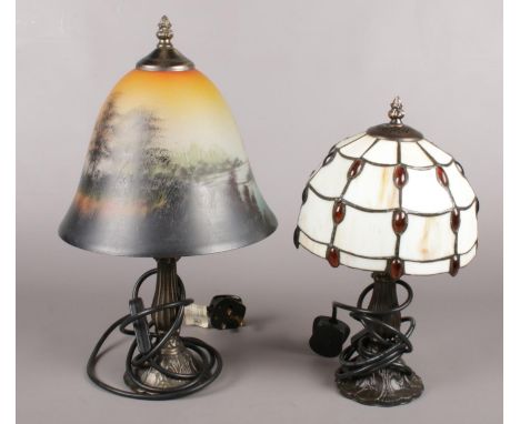 A Tiffany style lead glazed table lamp along with a similar example with painted glass landscape scene shade.  