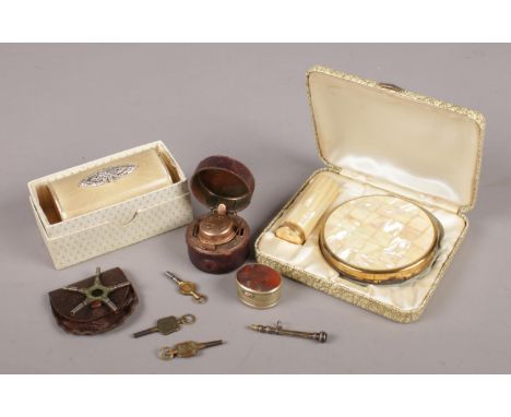 A group of collectables. Includes travelling ink well, white metal snuff box, pocket watch keys, compact etc.  