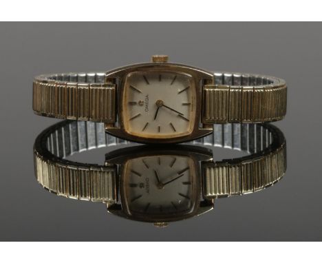 A ladies 9ct gold Omega manual wristwatch. With stainless steel expanding strap.  Running.