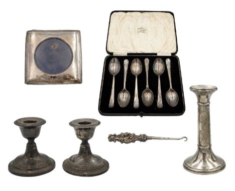 A selection of silver items. To include a pair of squat candlesticks, Birmingham 1908; one other candlestick, Birmigham 1920;