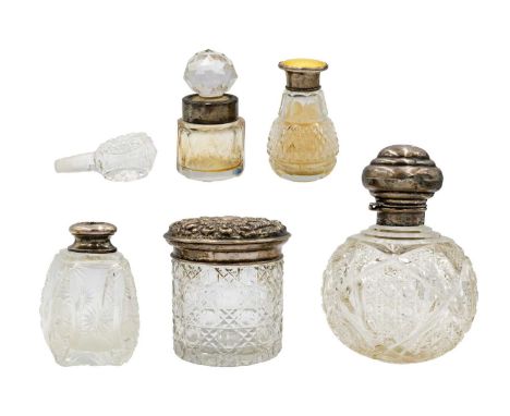A selection of five silver-mounted cut glass dressing table bottles. To include an Edwardian lidded jar, embossed with foliat